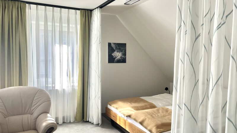 Badezimmer mit freistehender Badewanne, großem Waschbecken und Blick ins Grüne