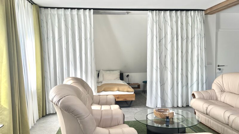 Eingangsbereich mit Garderobe, Sitzbank und grünem Teppichläufer