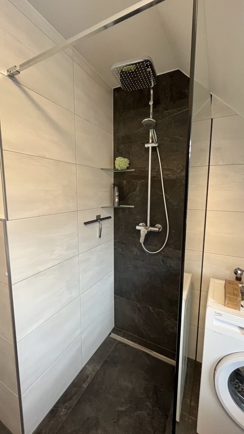 Essbereich mit vier Stühlen und Tisch in Marmoroptik vor einer Fensterfront