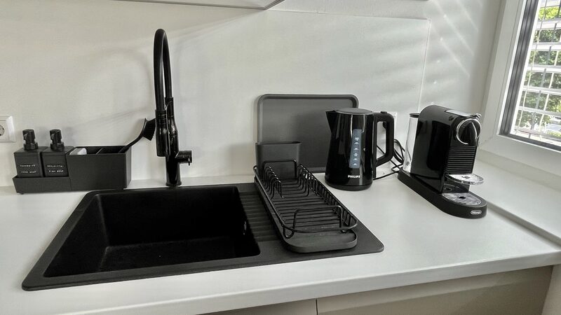 Badezimmer mit freistehender Wanne, großem Spiegel und moderner Beleuchtung