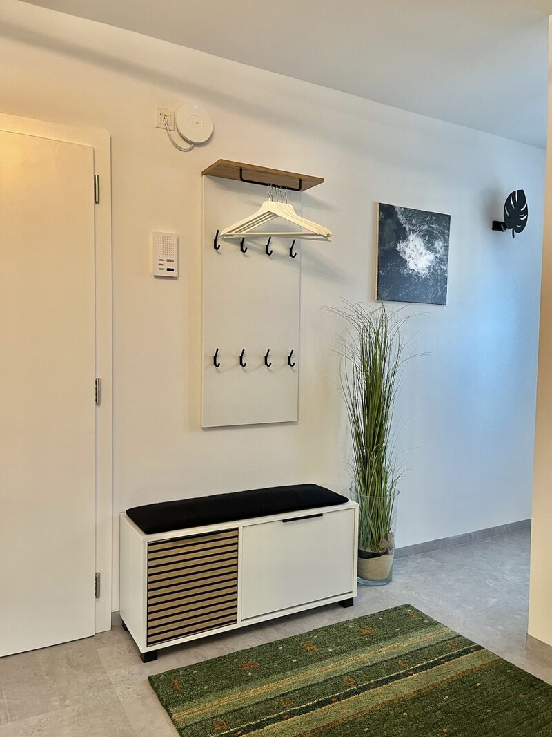 Badezimmer mit weißem Waschtisch, großem Spiegel und freistehender Wanne