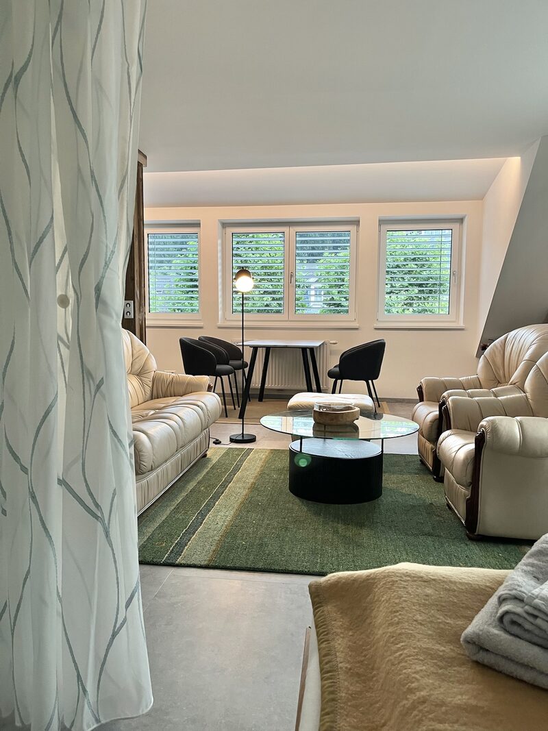 Blick vom Schlafzimmer in den Wohnbereich mit grünem Teppich